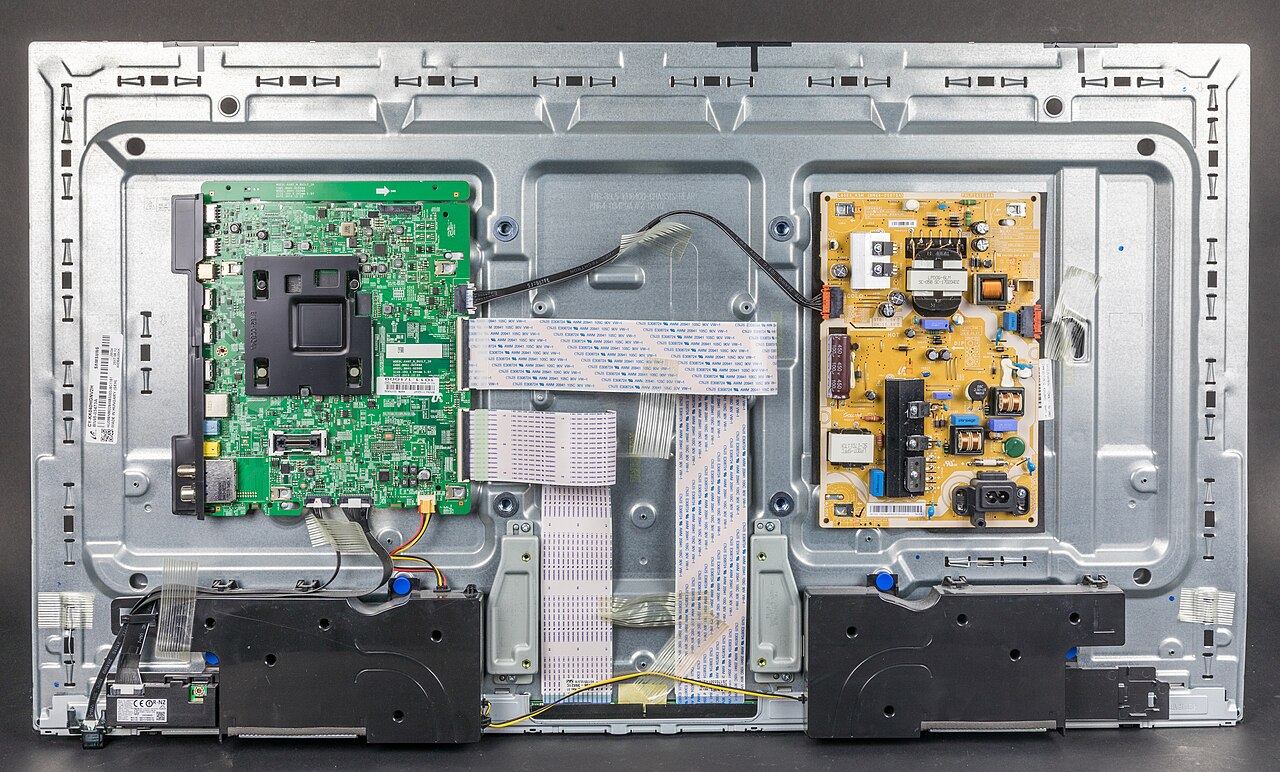 Opened LED LCD television showing its main board, power board, speakers and cables
